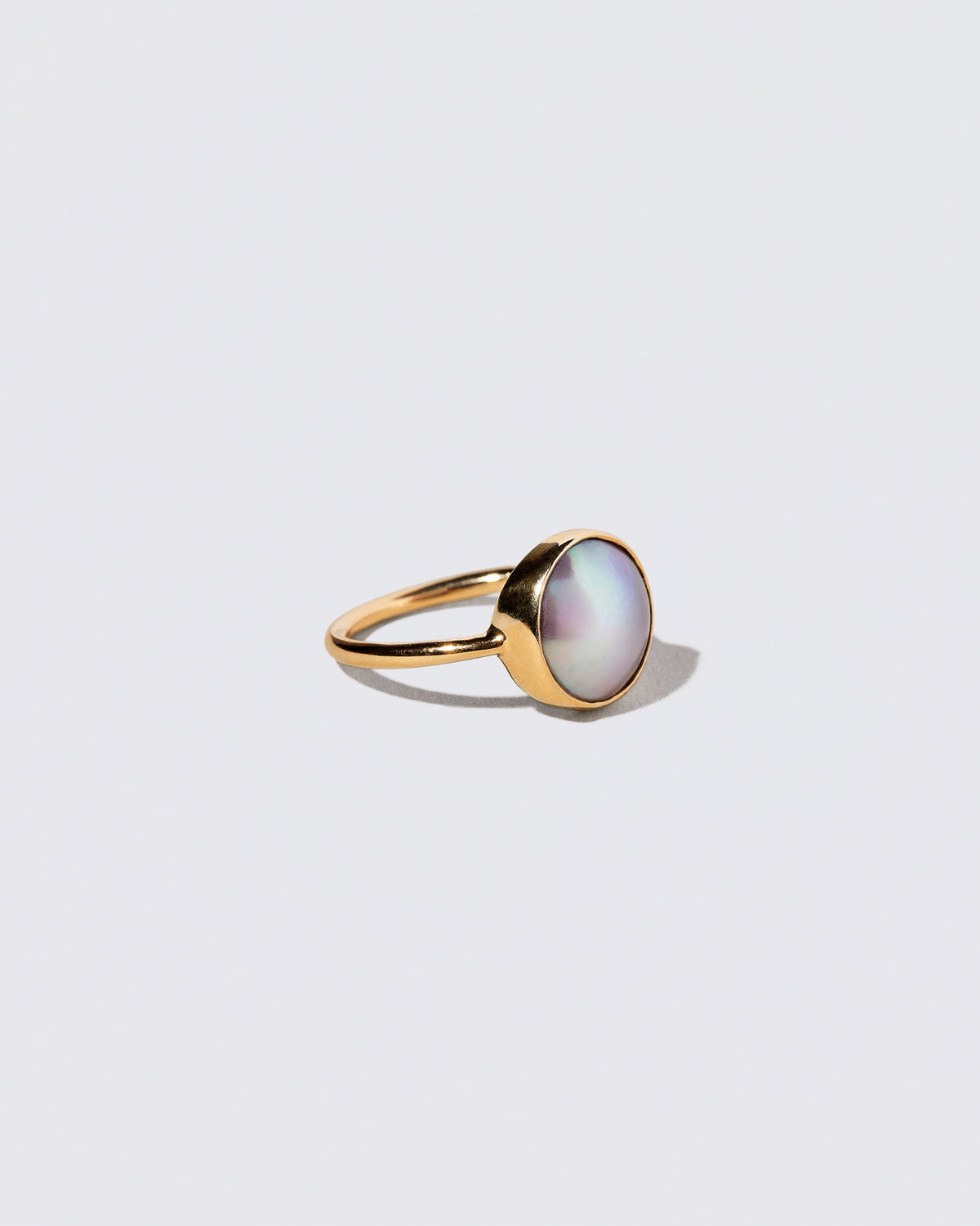 View from the side of the Gold Albert Ring on light color background.