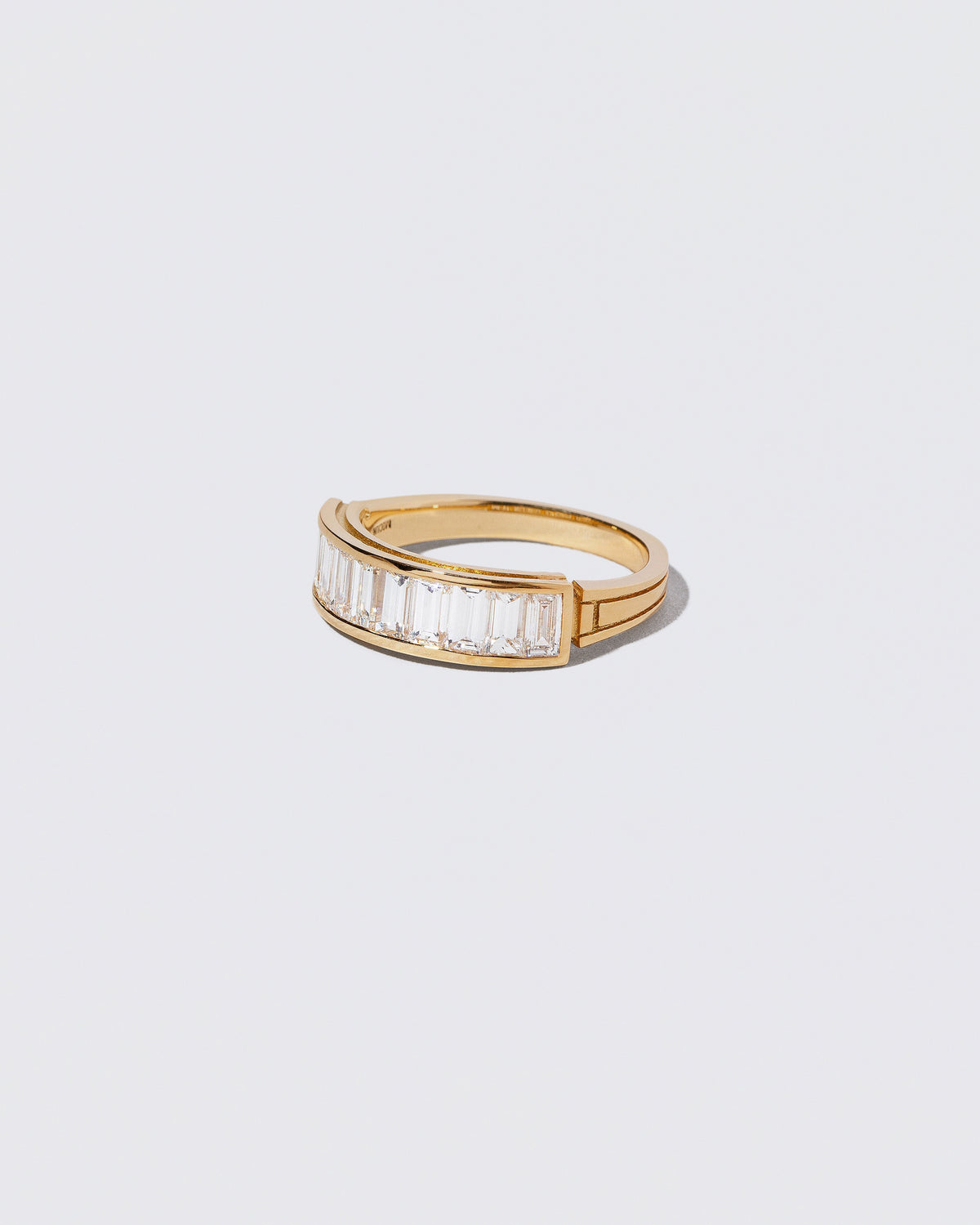 View from the side of the Gold Arcade Ring on light color background.
