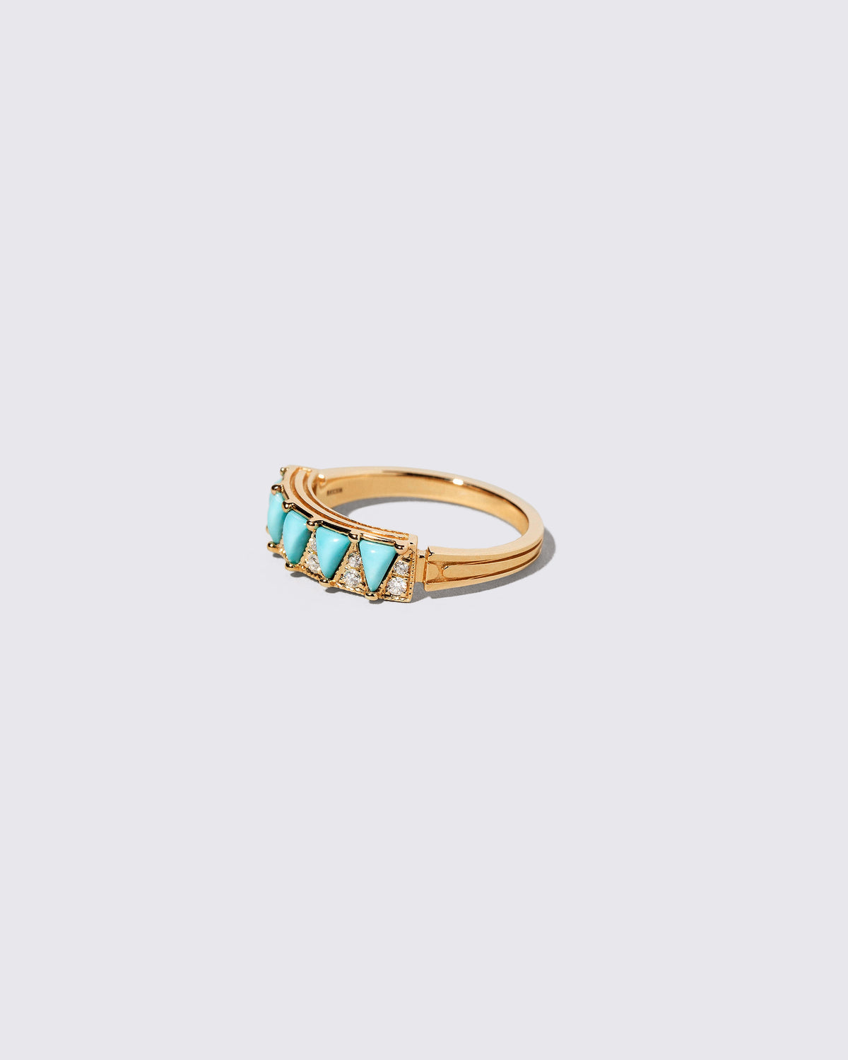 View from the side of the Gold Turquoise Five Triangle Ring on light color background.