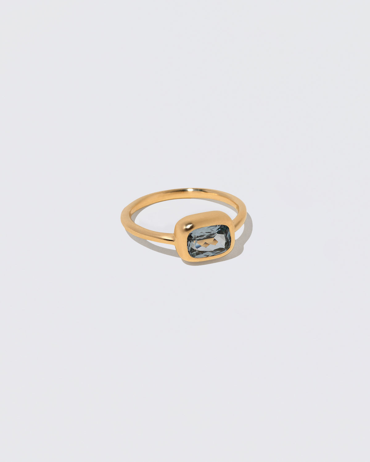 View from the side of the Geyser Light Blue Sapphire Ring 007 on light color background.