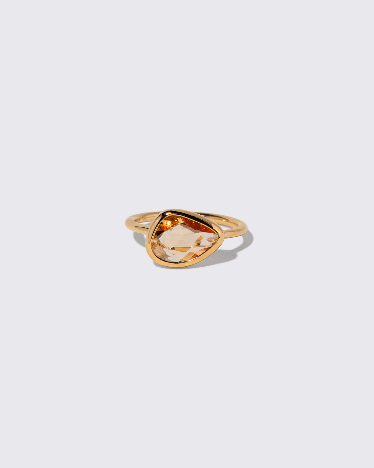 Peach Pink Sapphire Gusher Ring on light color background.