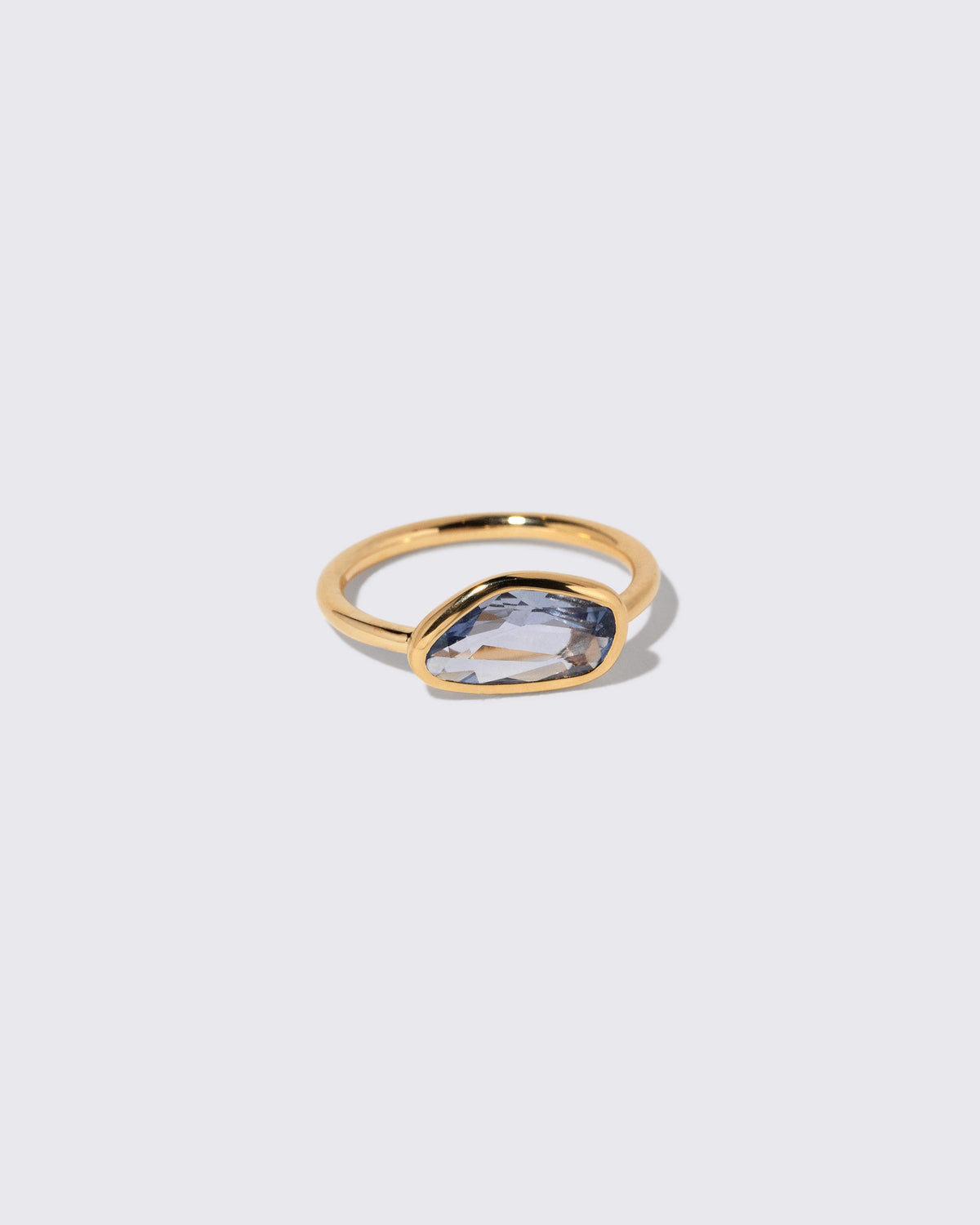 View from the side of the Blue Sapphire Gusher Ring on light color background.