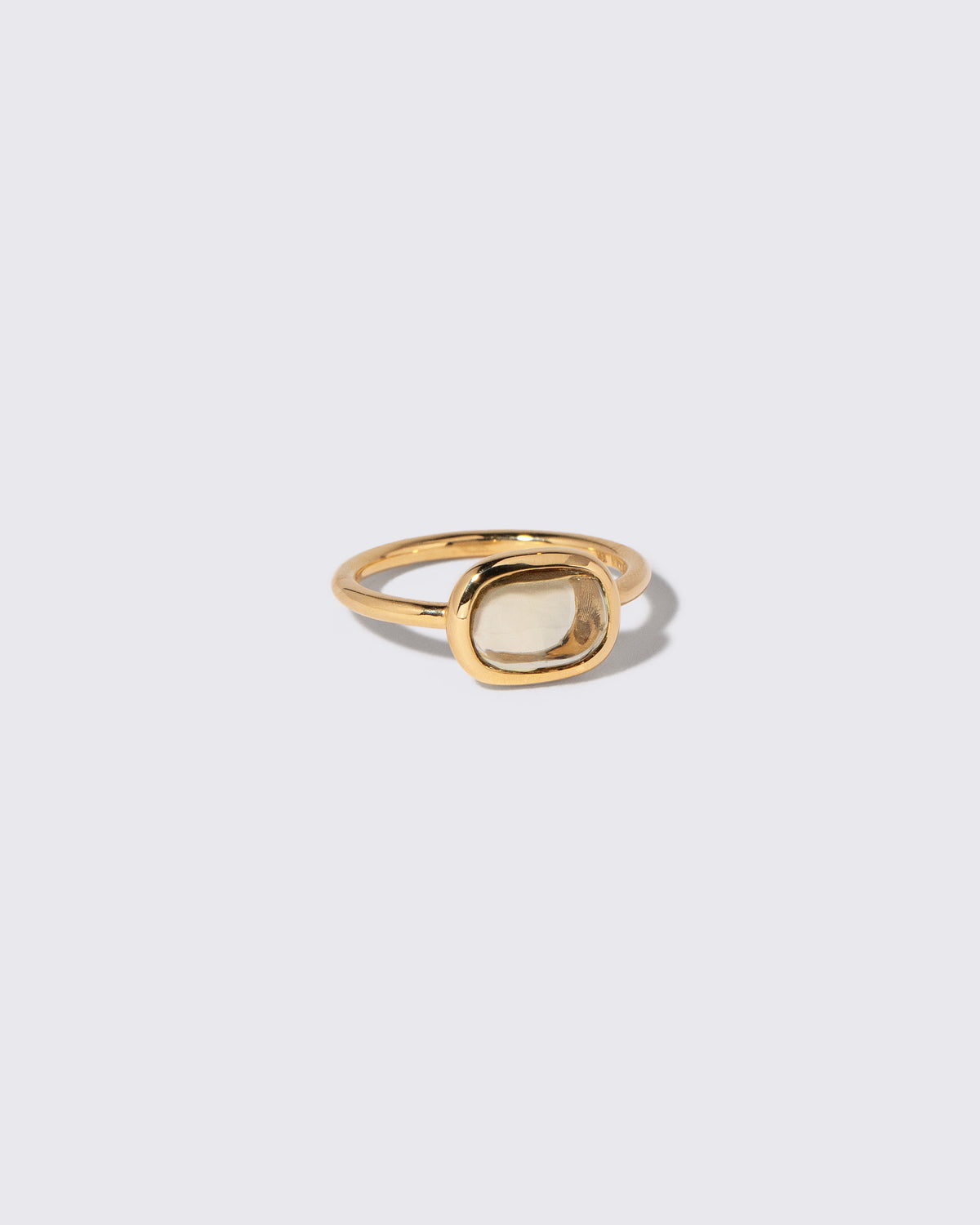 View from the side of the Green Sapphire Gusher Ring on light color background.
