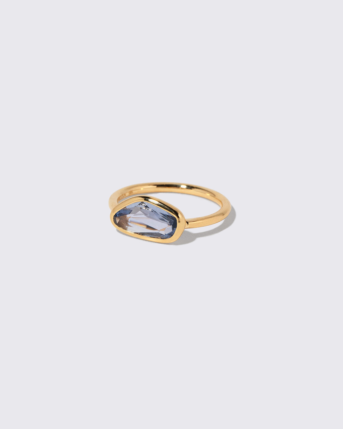 View from the side of the Blue Sapphire Gusher Ring on light color background.