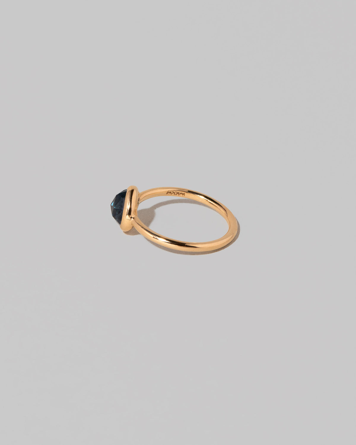 View from the back of the Gusher Blue Sapphire Ring 005 on light color background.