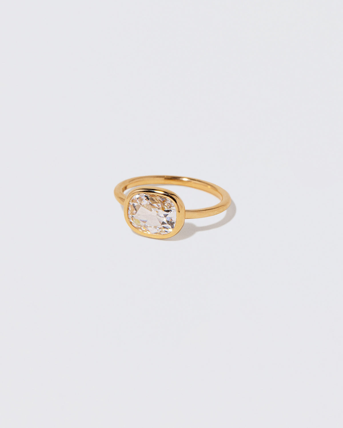 View from the side of the Cushion Diamond Gusher Ring on light color background.