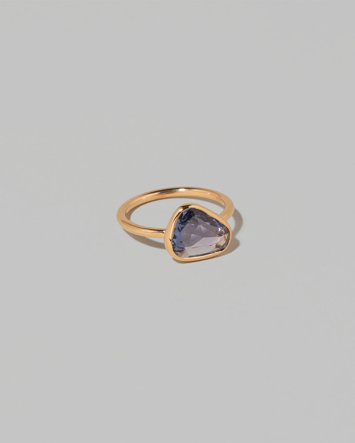 View from the side of the Gusher Purple Sapphire Ring 001 on light color background.
