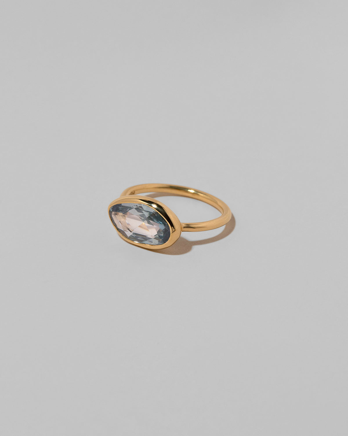 View from the side of the Gusher Blue Sapphire Ring 039 on light color background.