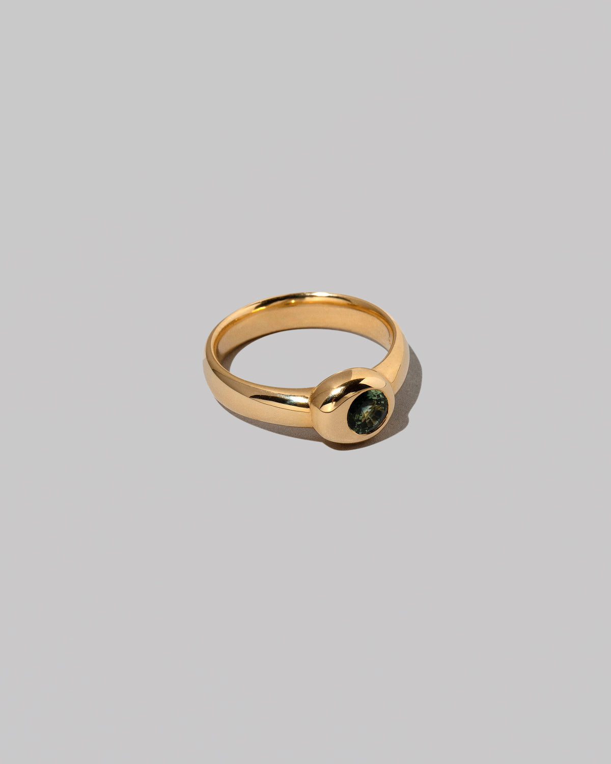 View from the side of the Green Sapphire Level Ring on light color background.