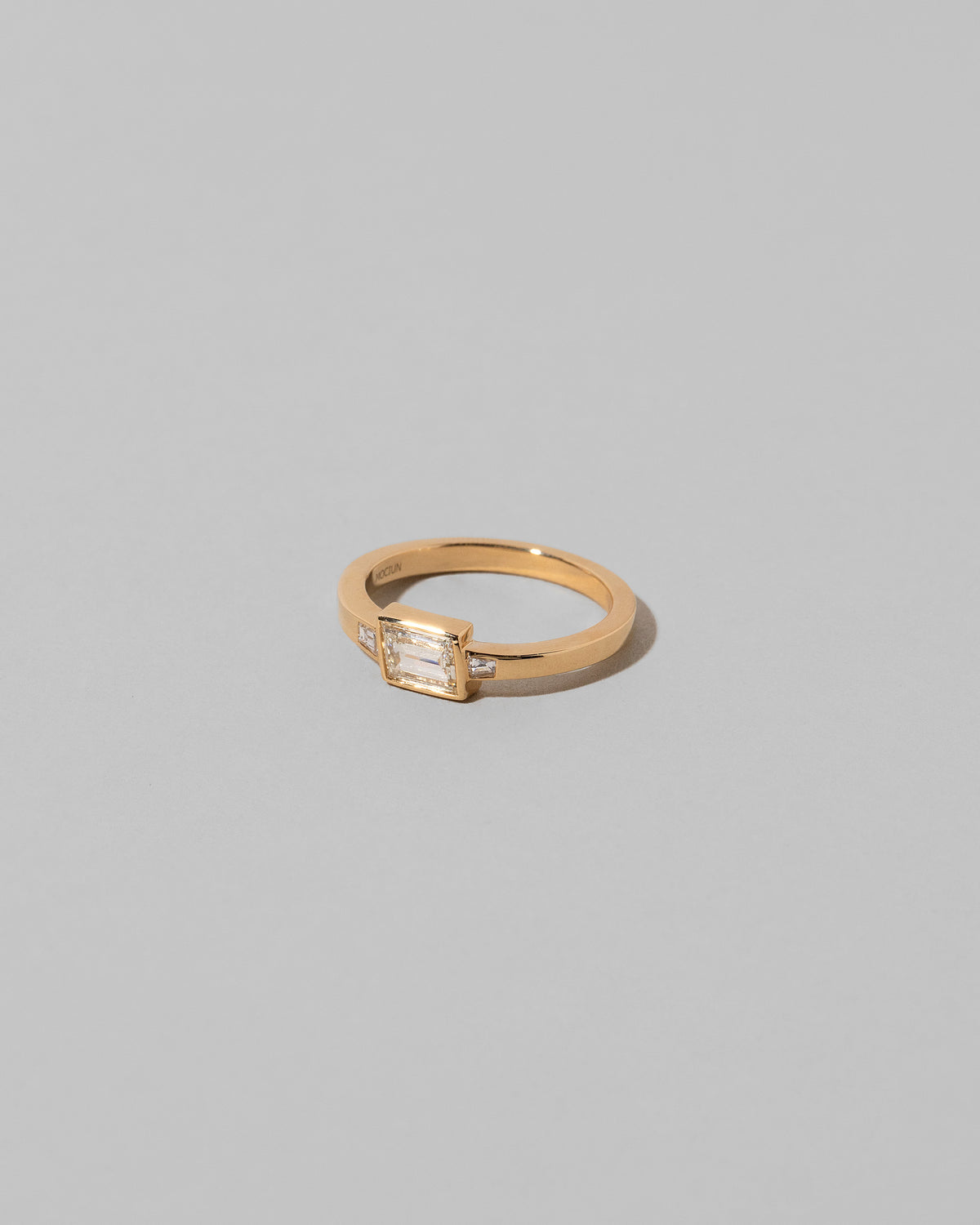 View from the side of the That Way Ring on light color background.