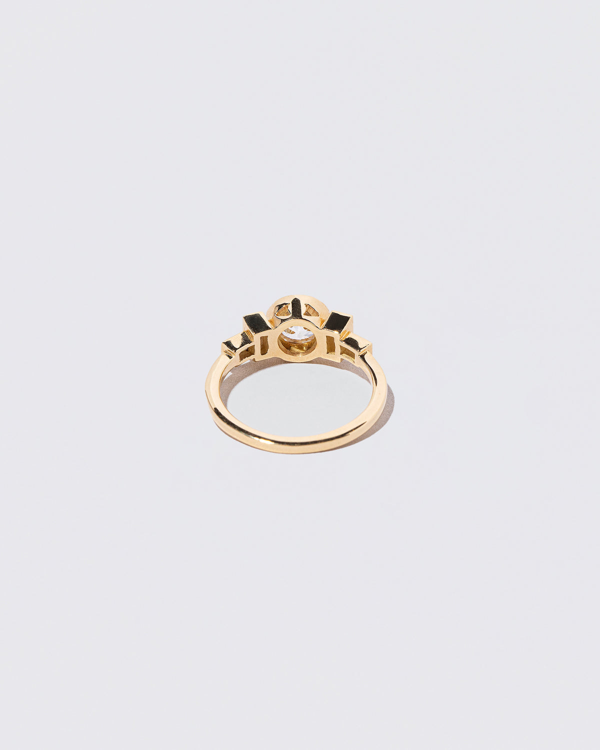 View from the back of the White Diamond & Blue Sapphire Third Eye Ring on light color background.