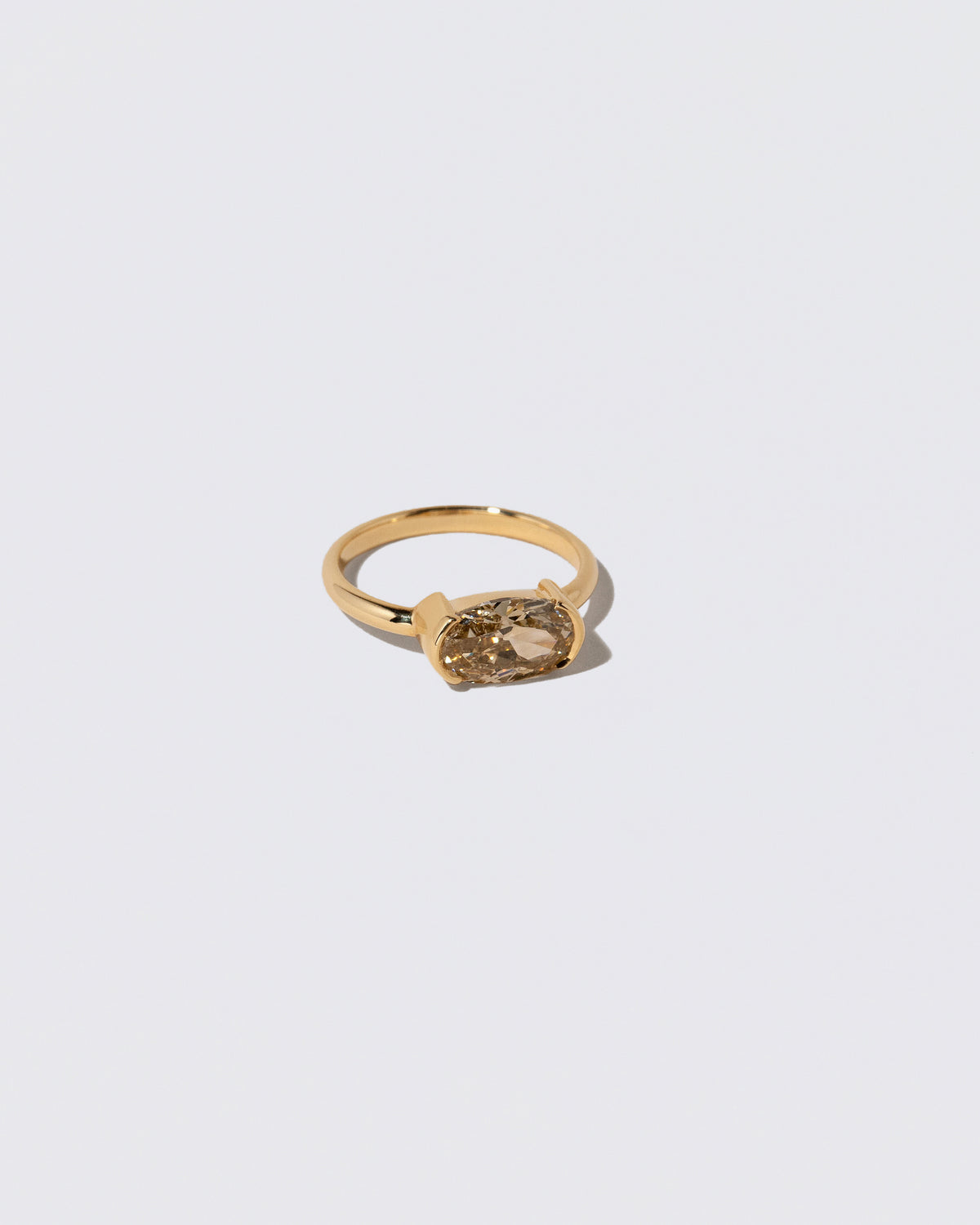 View from the side of the Oval Brown Diamond Transformation Ring on light color background.
