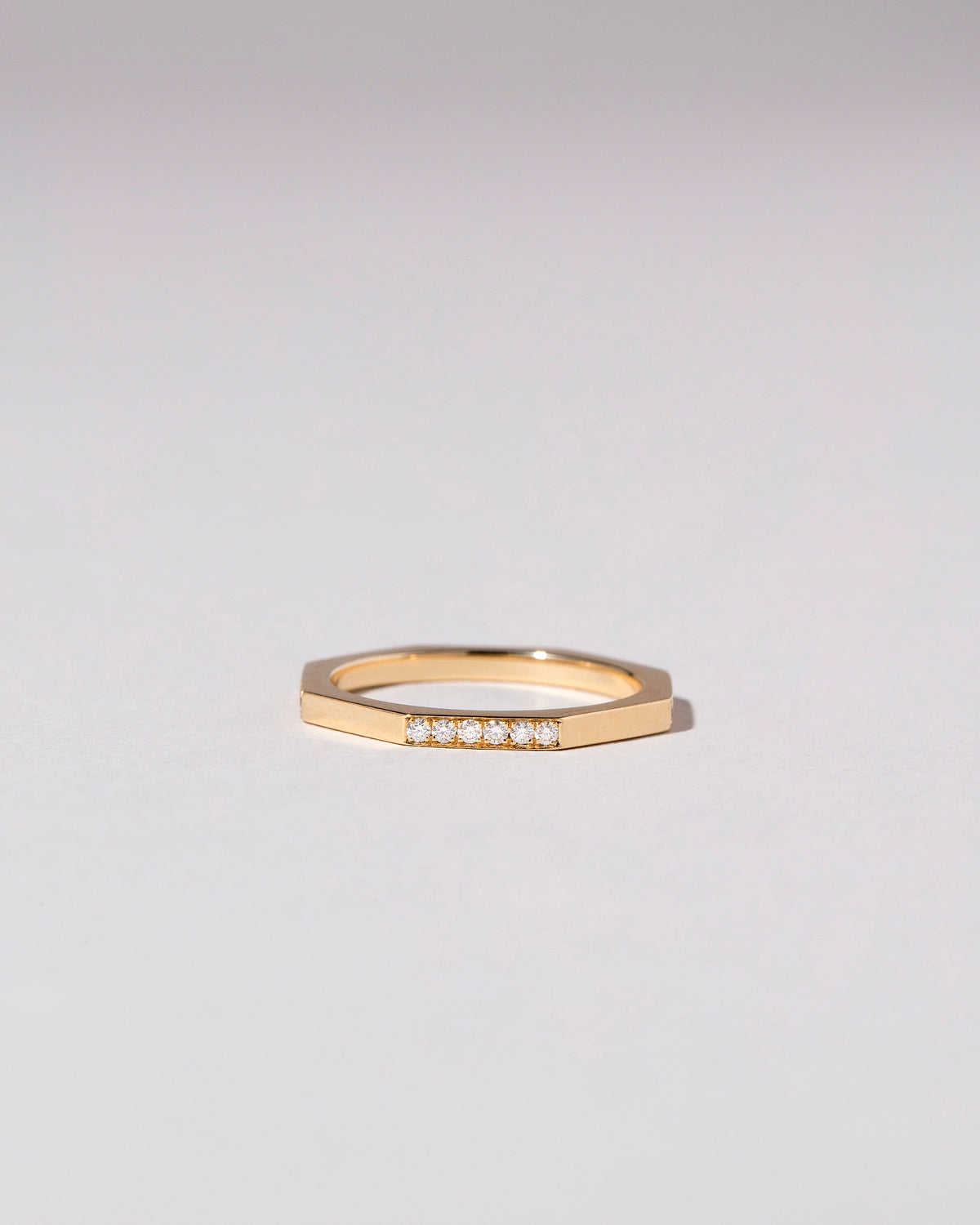 Gold 1.7mm Single Side Pavé Segmented Band on light color background.