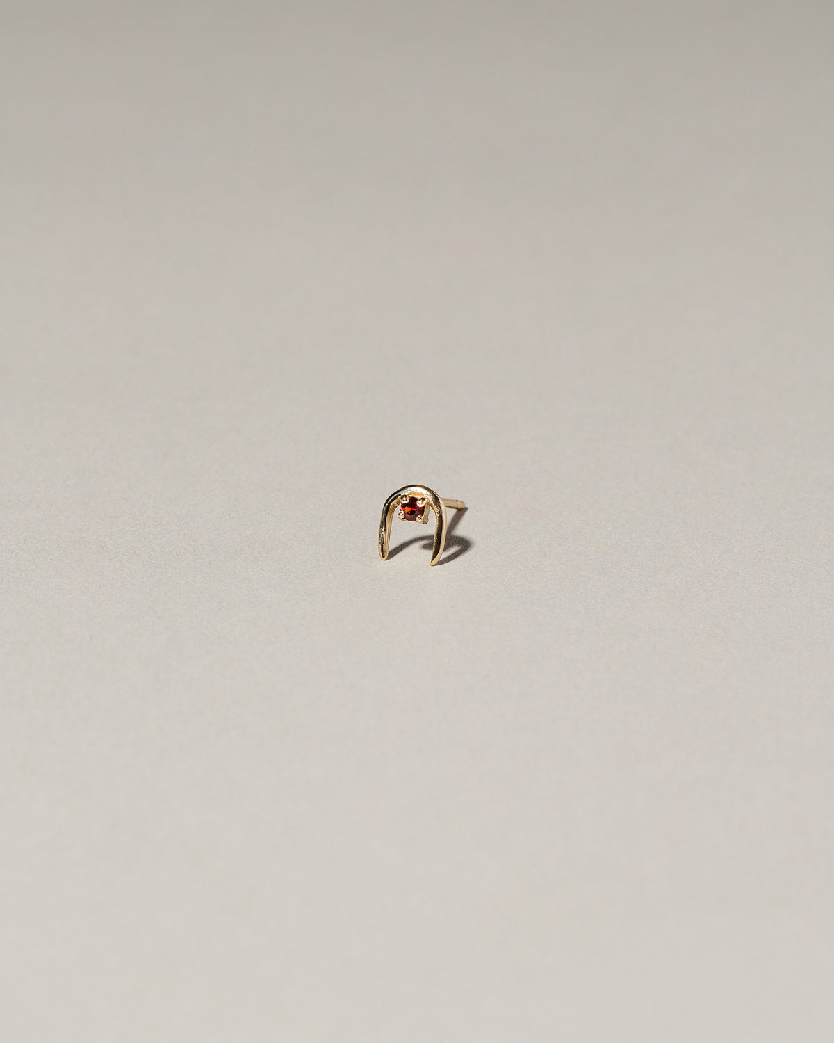 Garnet Moon Catcher Stud Earring Single on light color background.