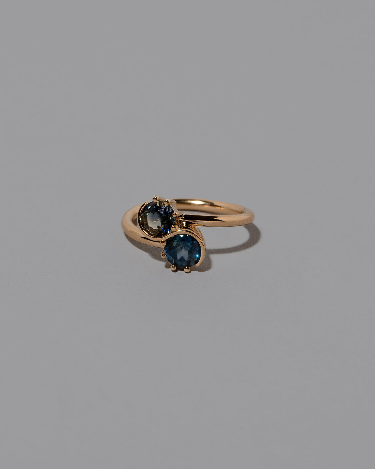 View from the side of the Sapphire Sun & Moon Union Ring on light color background.