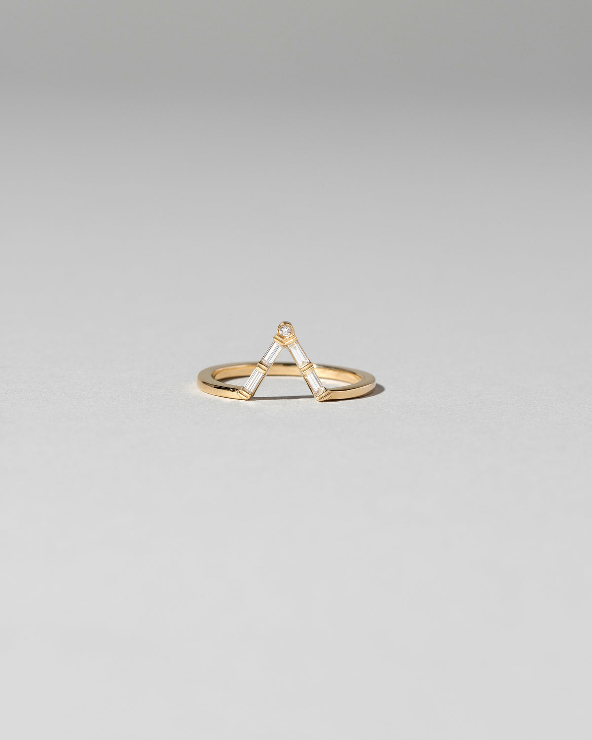 Gold Baguette Triangle Band on light color background.