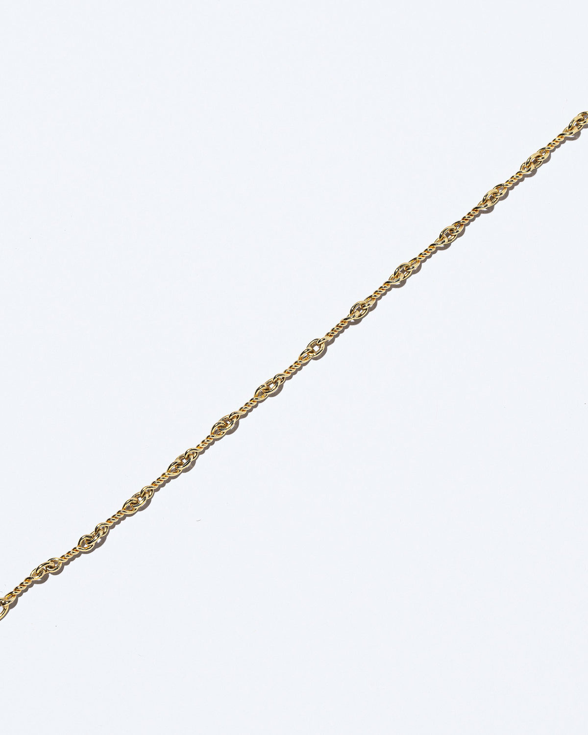 Closeup details of the Twisted Chain Necklace on light color background.