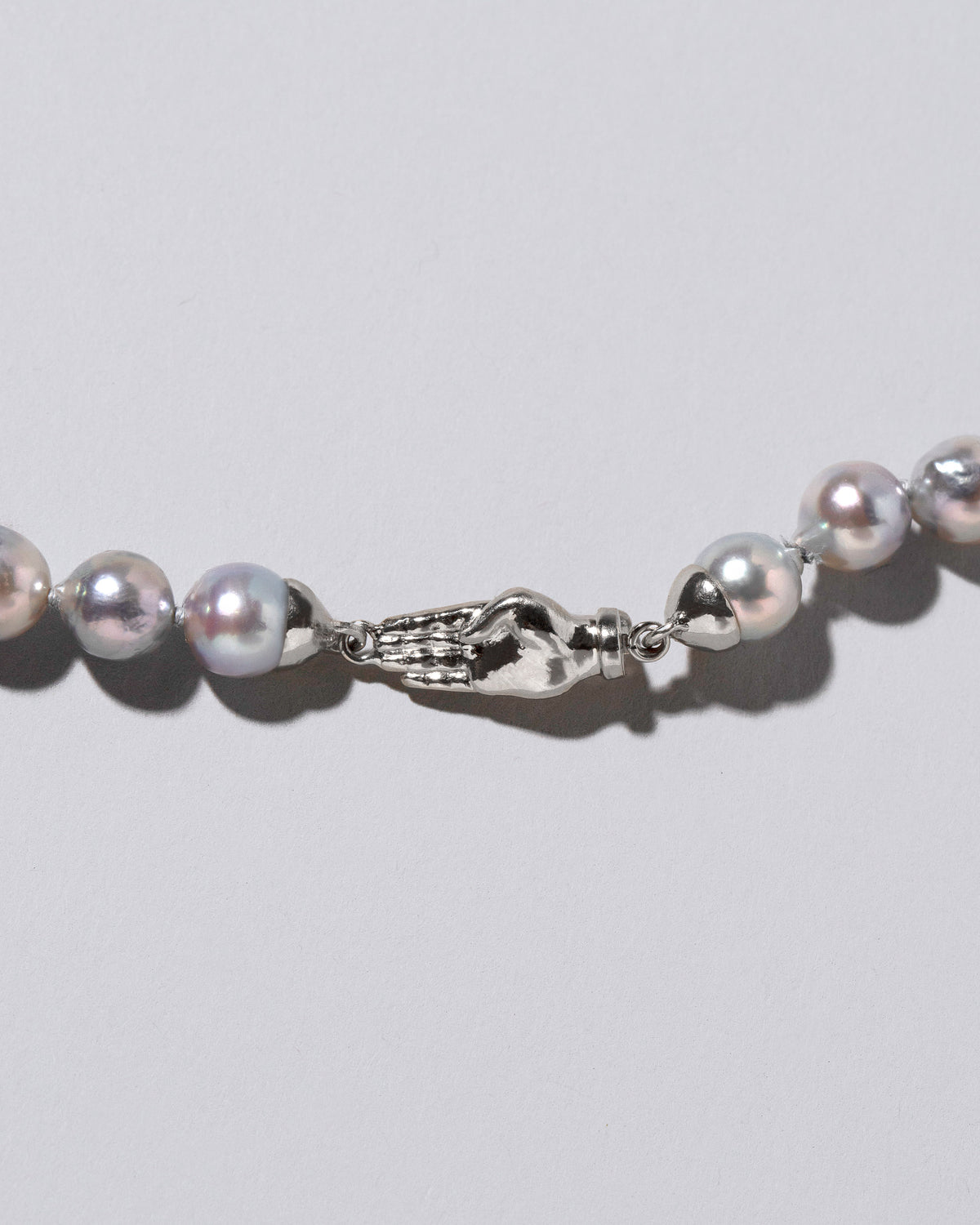 Closeup detail of the Blue Pearl & White Gold Union Pearl Necklace on light color background.