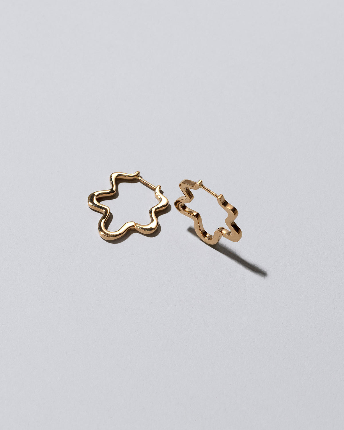 Closeup details of the Gold Wild Poppies Hoop Earrings on light color background.