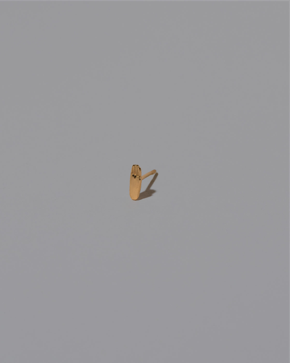Hand Stud Earring Single on light color background.