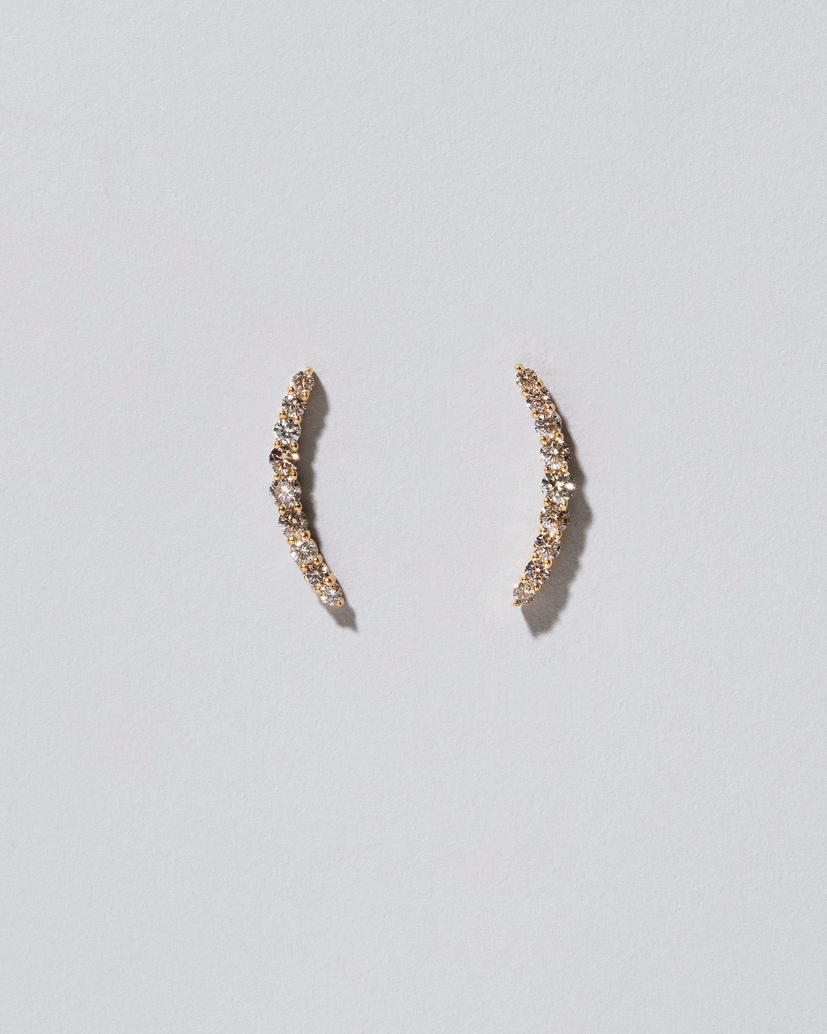 Crescent Ear Climber Stud Earrings - Champagne Diamond on light color background.