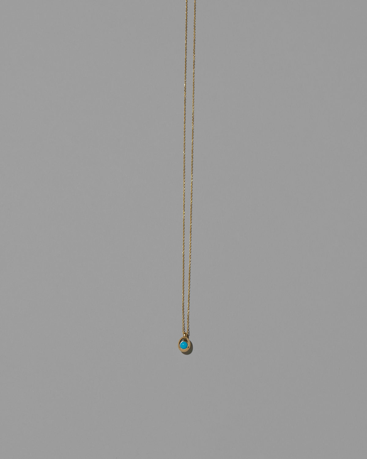 Turquoise Cabochon Birthstone Level Necklace on light color background.