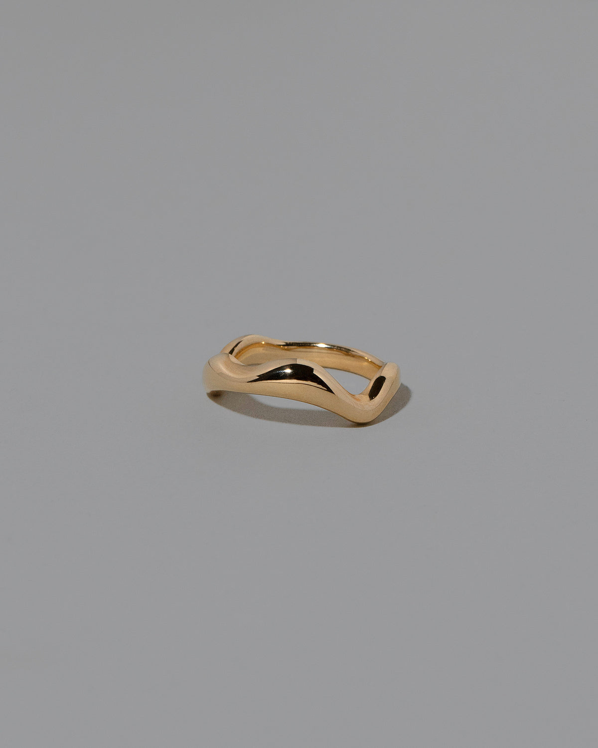 View from the side of the Gold Wide Fluctuating Band on light color background.