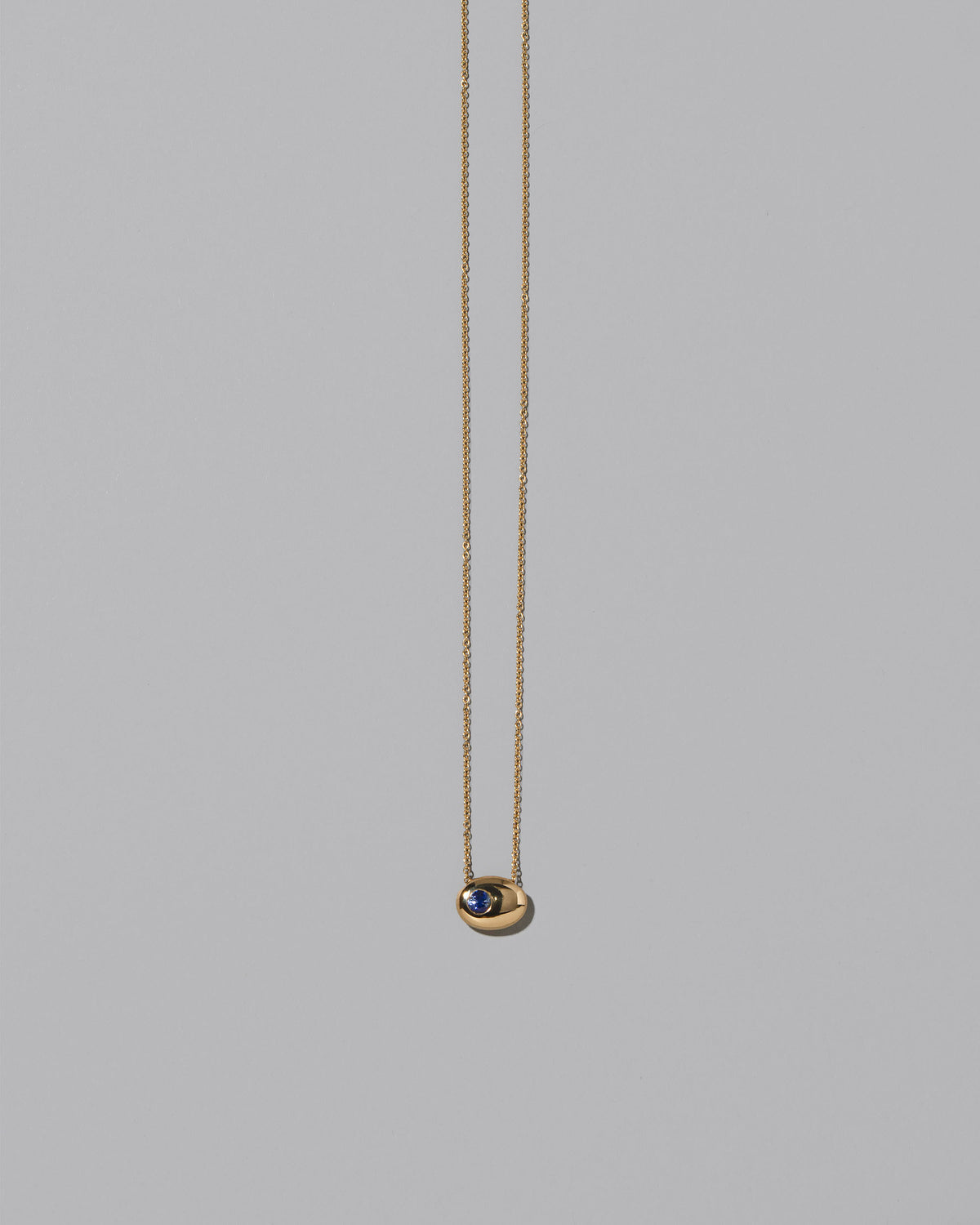 Gold Bicolor Blue Sapphire Level Necklace on light color background.