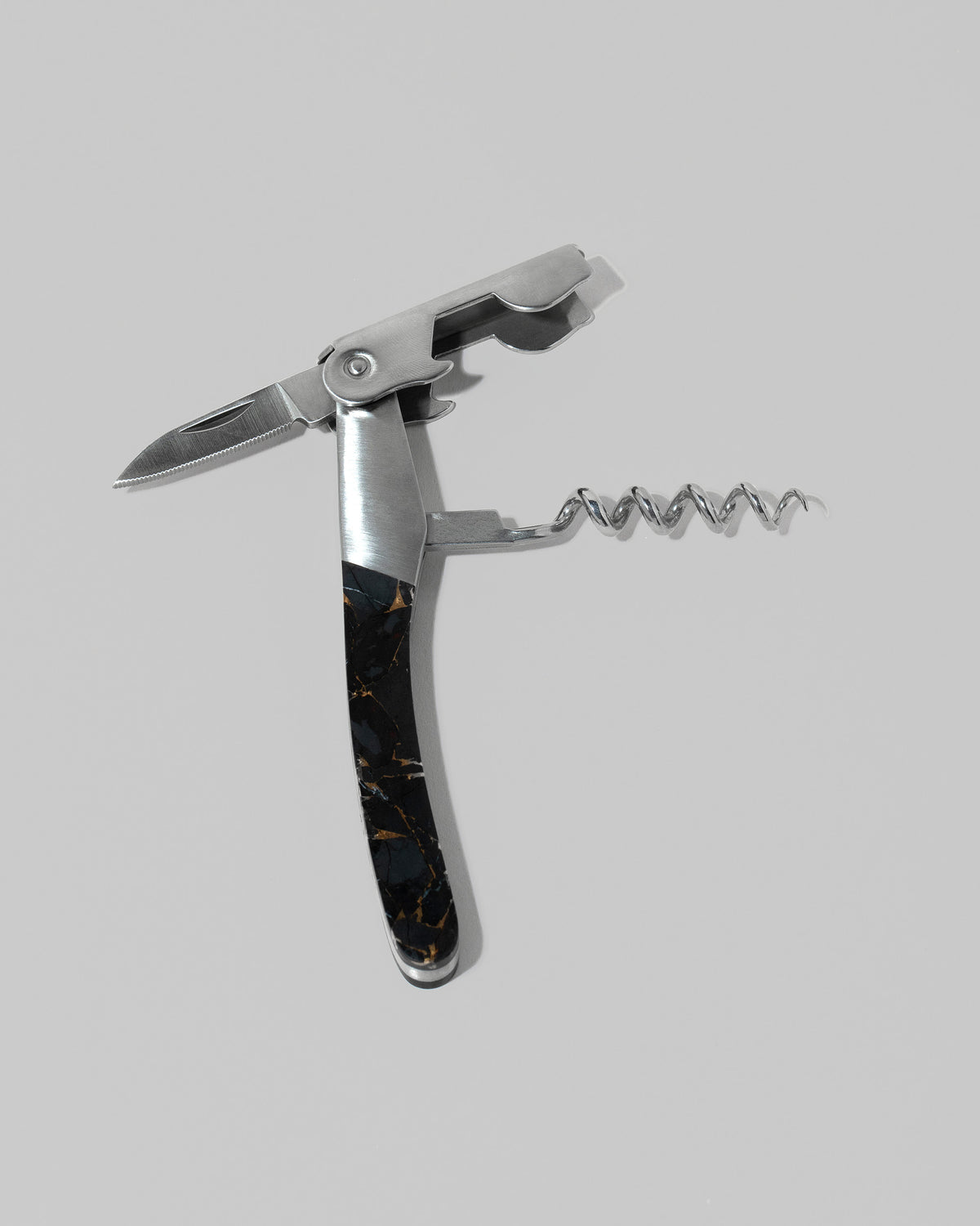 Detail view of the Santa Fe Stoneworks Black Buffalo Turquoise Waiter's Knife on light color background.