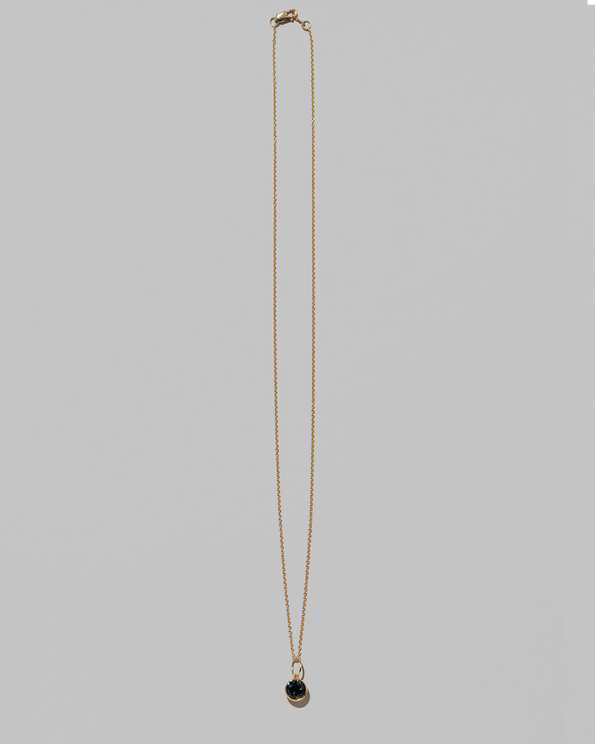 Bicolor Sapphire Pendant paired with chain on light color background.