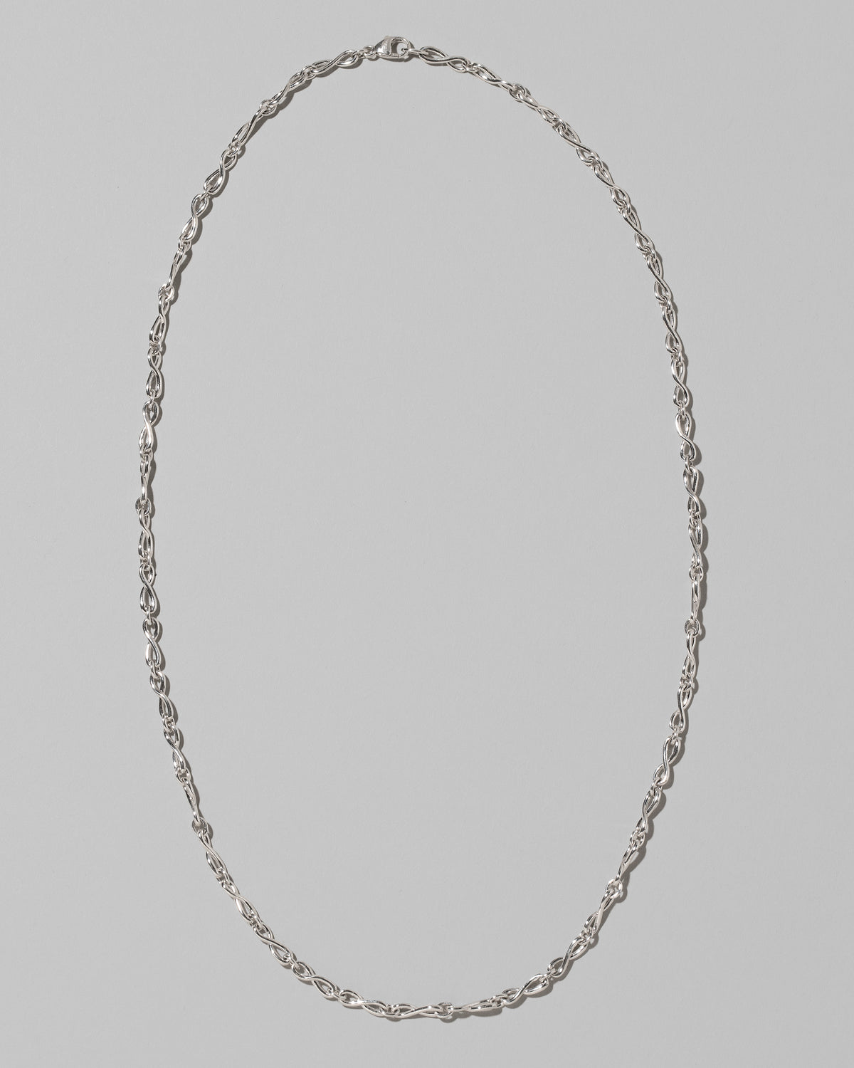CRZM Sterling Silver Infinity Chain Necklace on light color background.