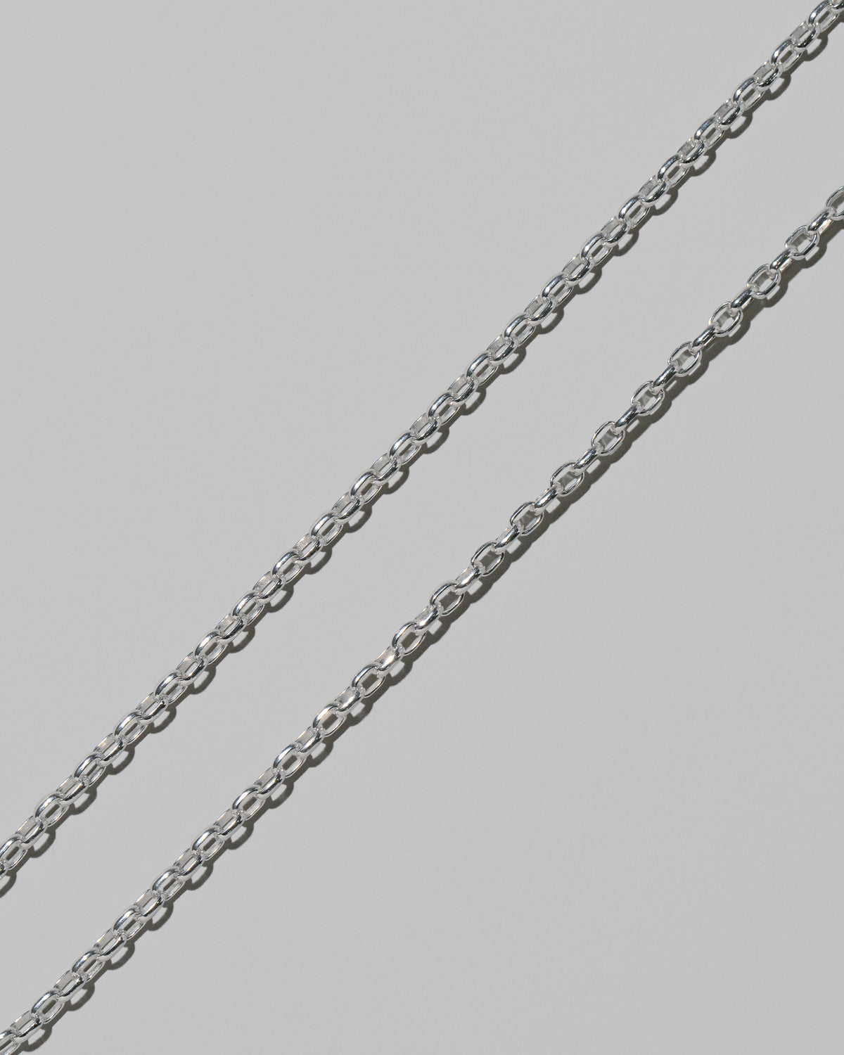 Closeup details of the CRZM 3.2mm Sterling Silver Short Loop Chain Necklace on light color background.