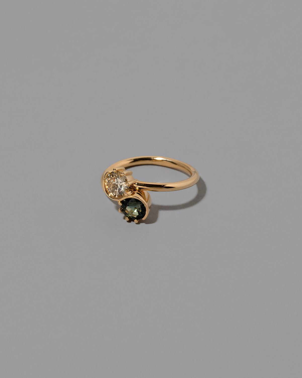 View from the side of the Sapphire & Champagne Diamond Sun & Moon Union Ring on light color background.