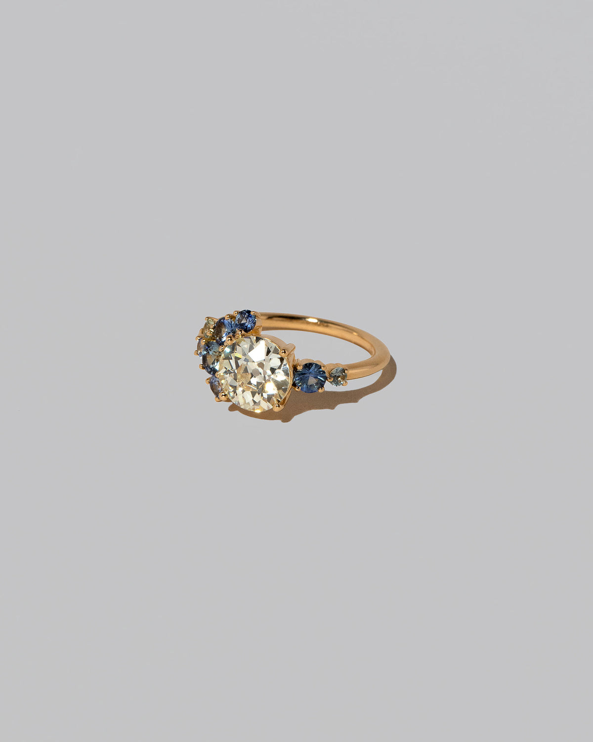 View from the side of the Diamond & Sapphire Vega Ring on light color background.