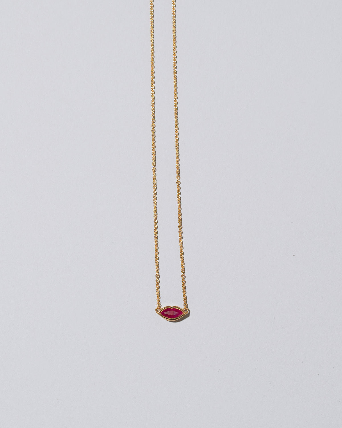 Red Big Kiss Necklace on light color background.