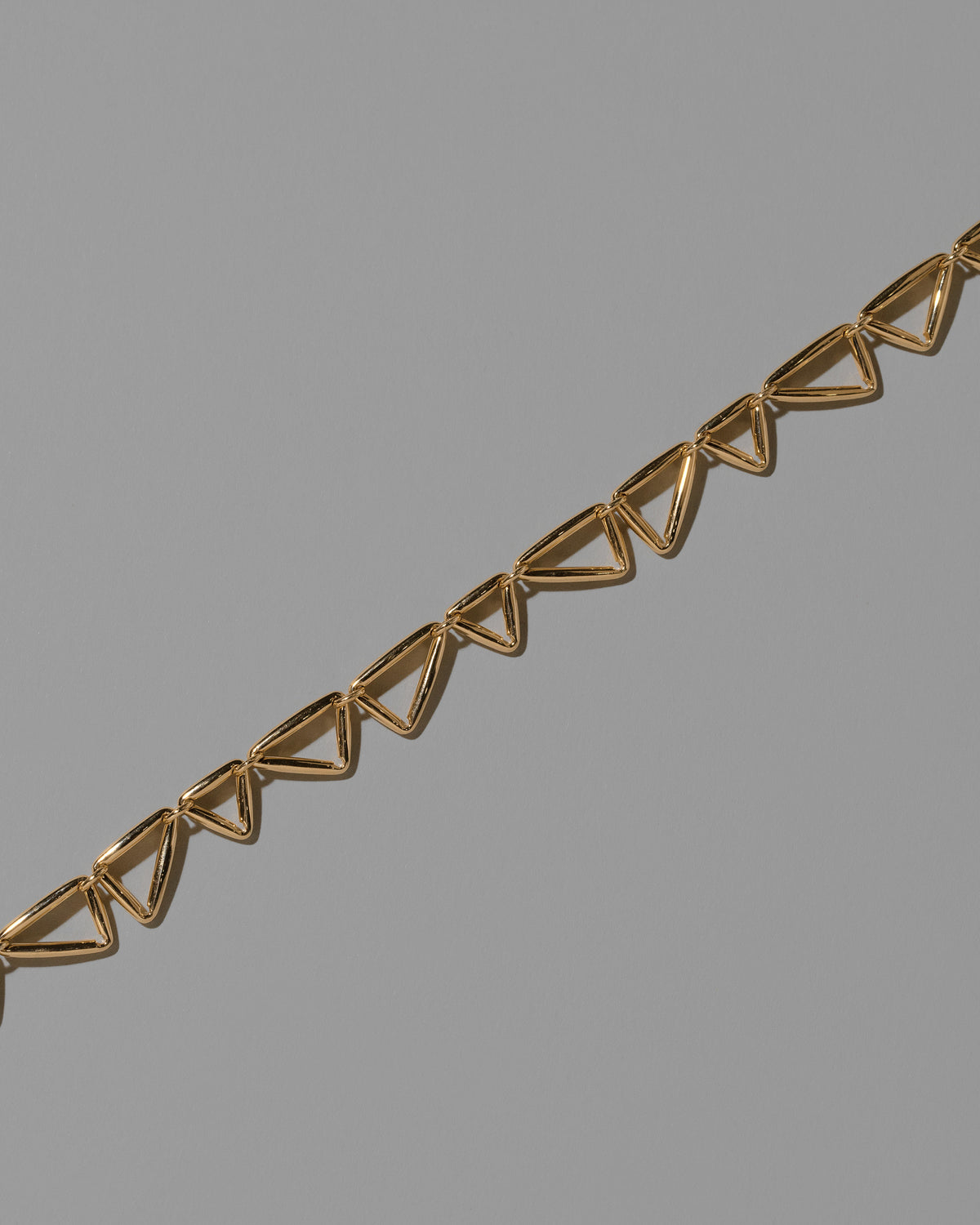 Closeup details of the Gold Flexure Necklace on light color background.