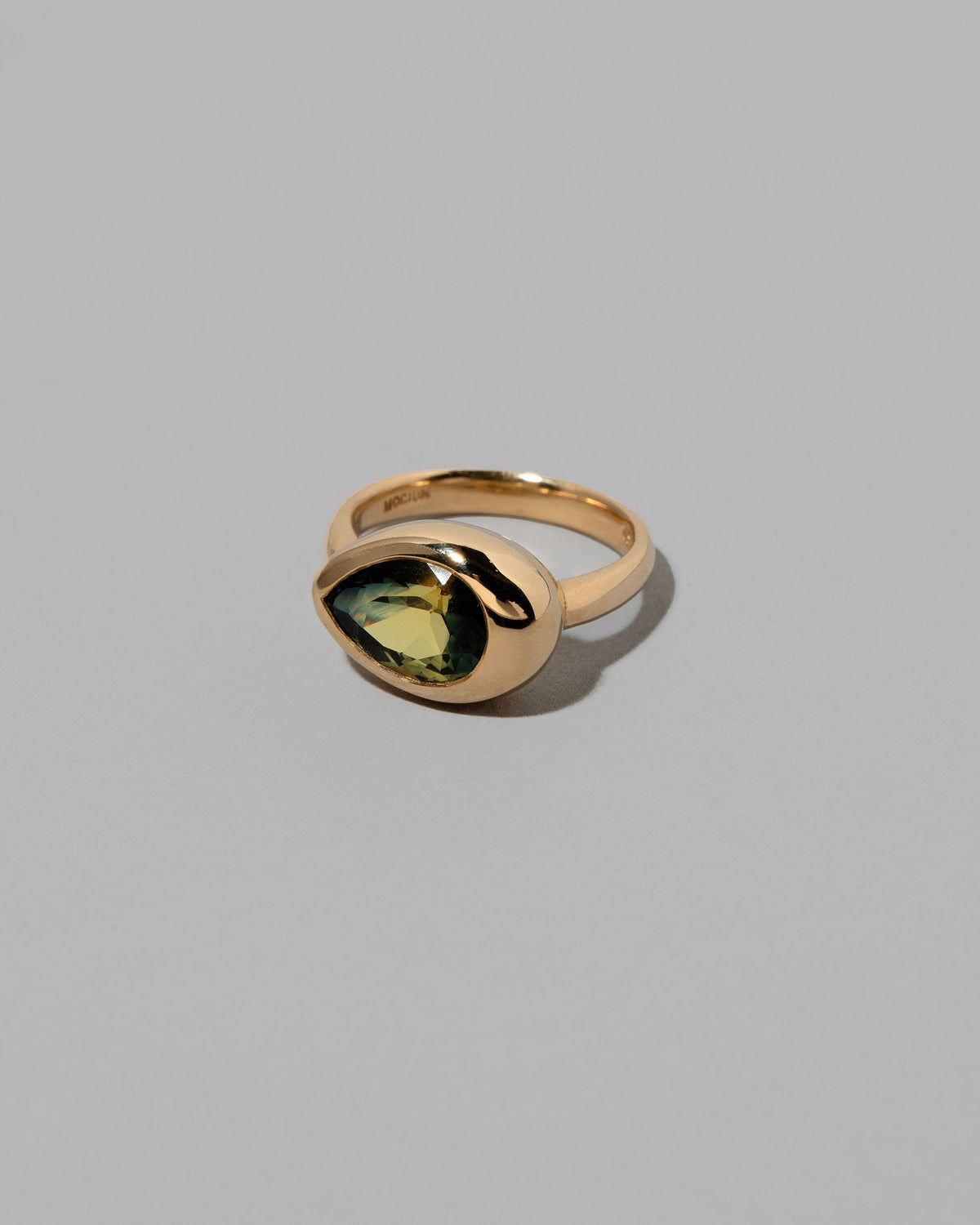 View from the side of the Bicolor Sapphire Grand Align Ring on light color background.