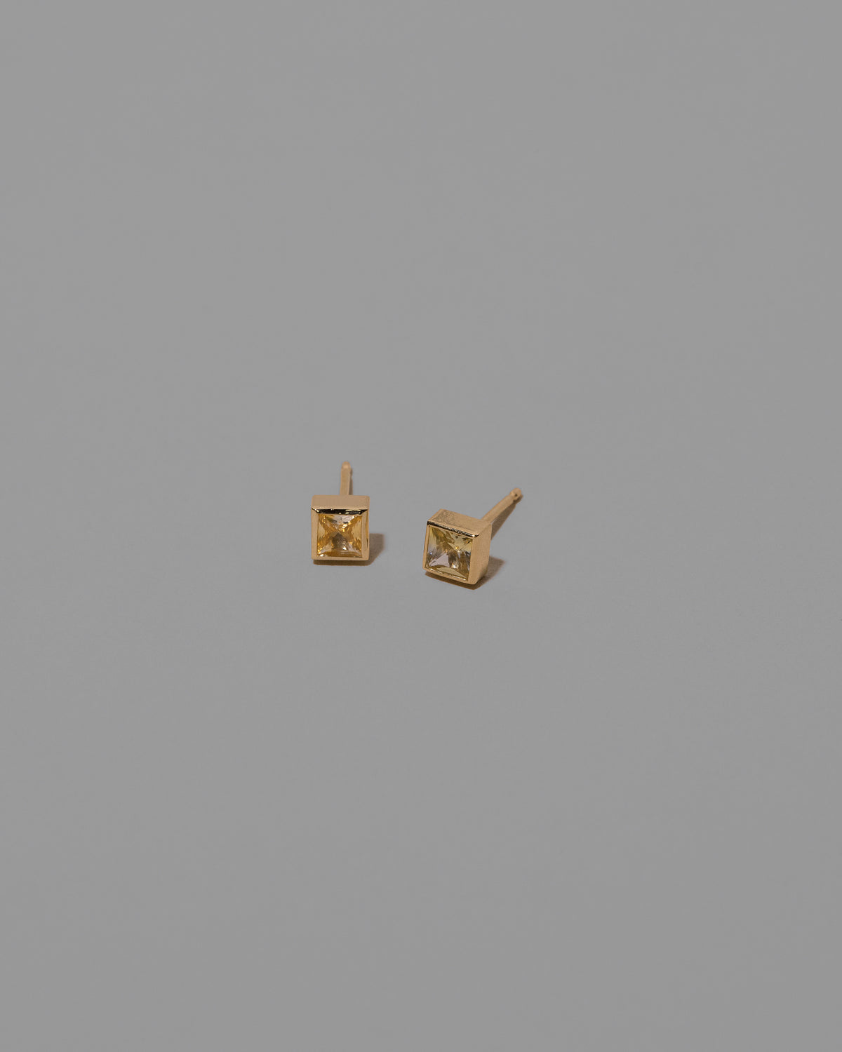 Bicolor Sapphire Square Frame Stud Earrings on light color background.