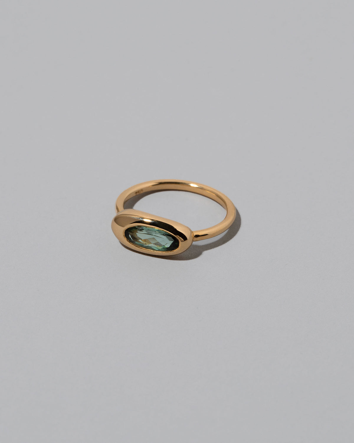 View from the side of the Tourmaline Equalize Ring on light color background.