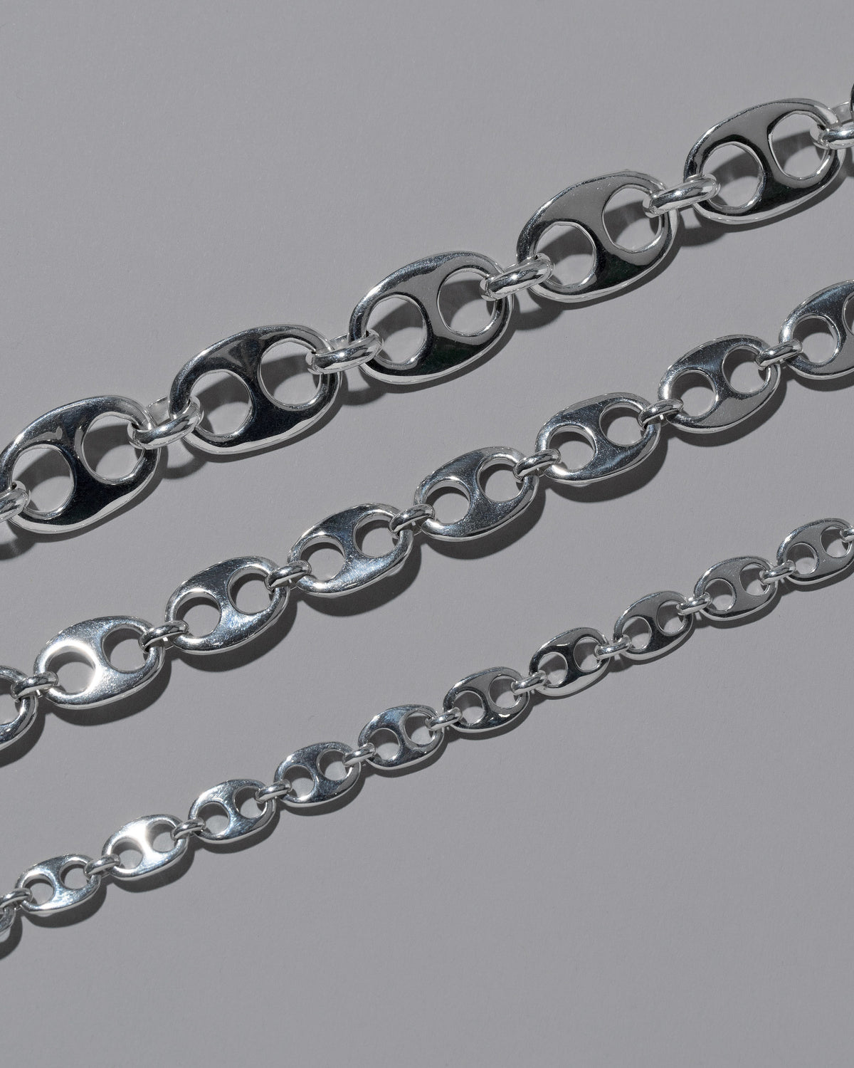Closeup details of the CRZM Sterling Silver Yuba Mini Bracelet, Sterling Silver Yuba Medium Bracelet, and Sterling Silver Yuba Bracelet on light color background.