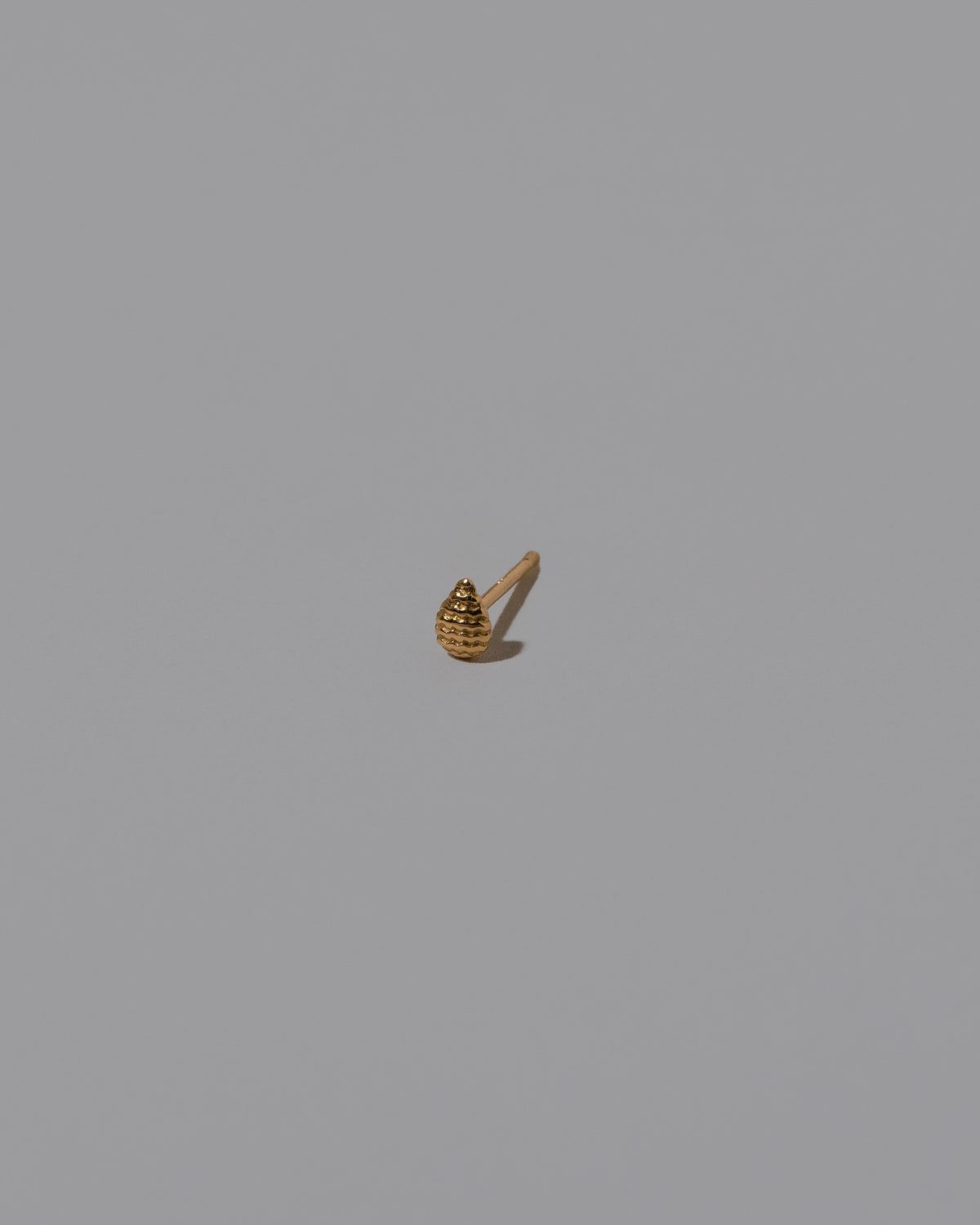 Tear Stud Earring Single on light color background.