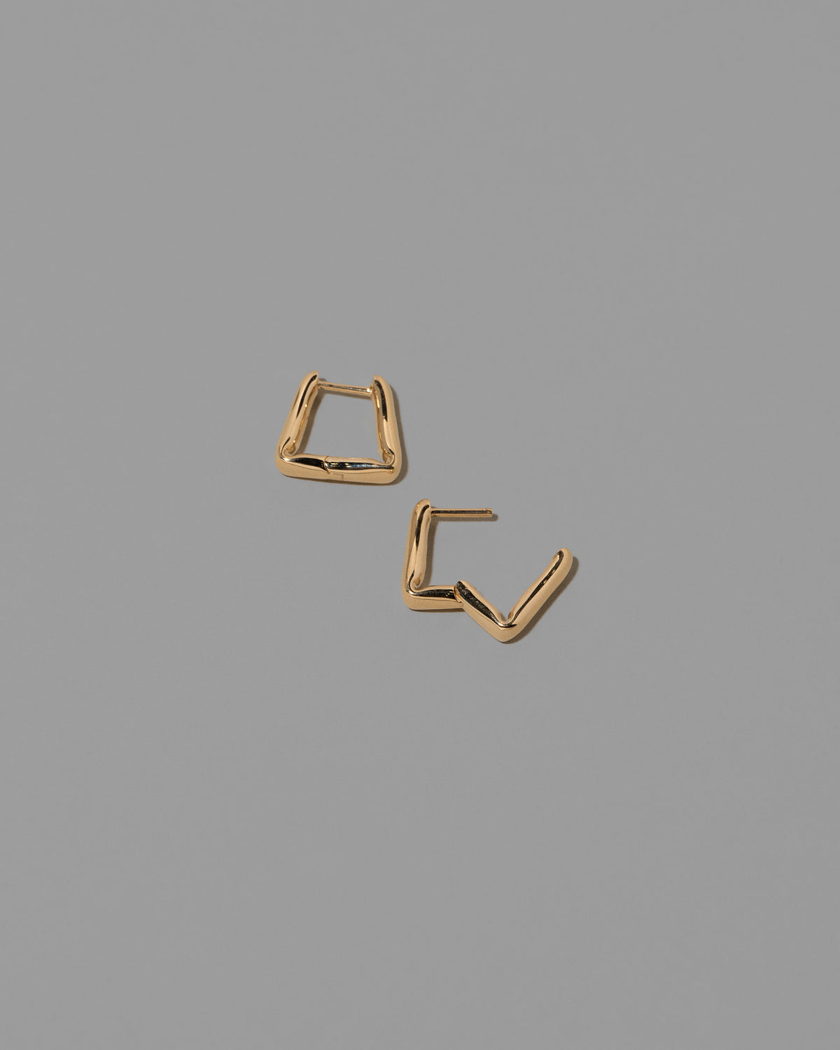 Detail view of the Gold Kink Hoop Earrings on light color background.