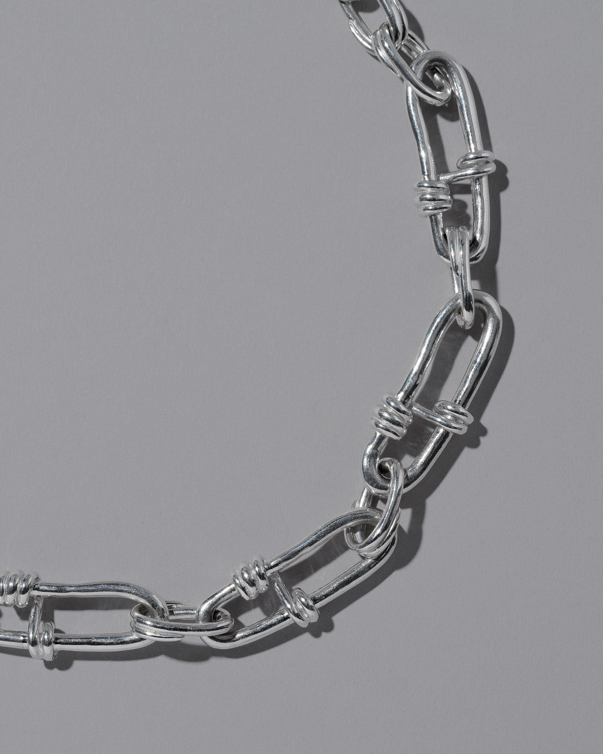 Closeup details of the CRZM Sterling Silver Canyon Necklace on light color background.