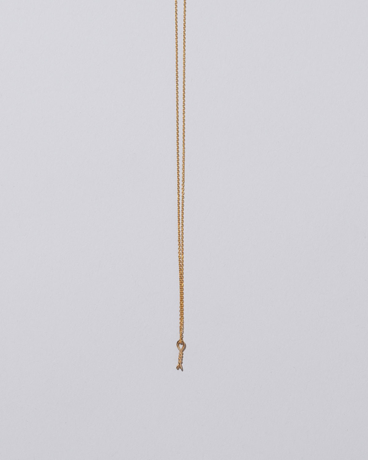 Twist Talisman Pendant Necklace on light color background.