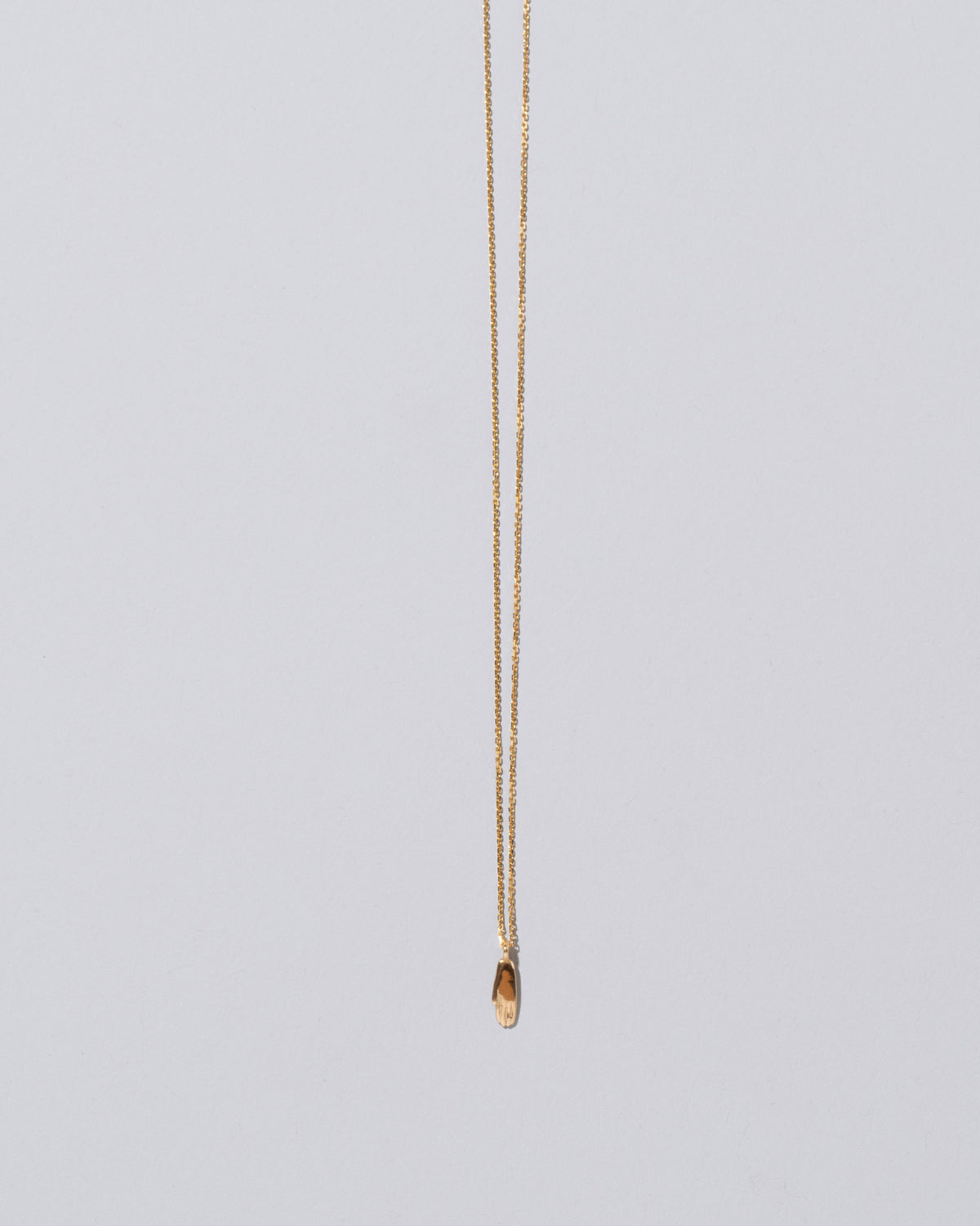 Hand Talisman Pendant Necklace on light color background.