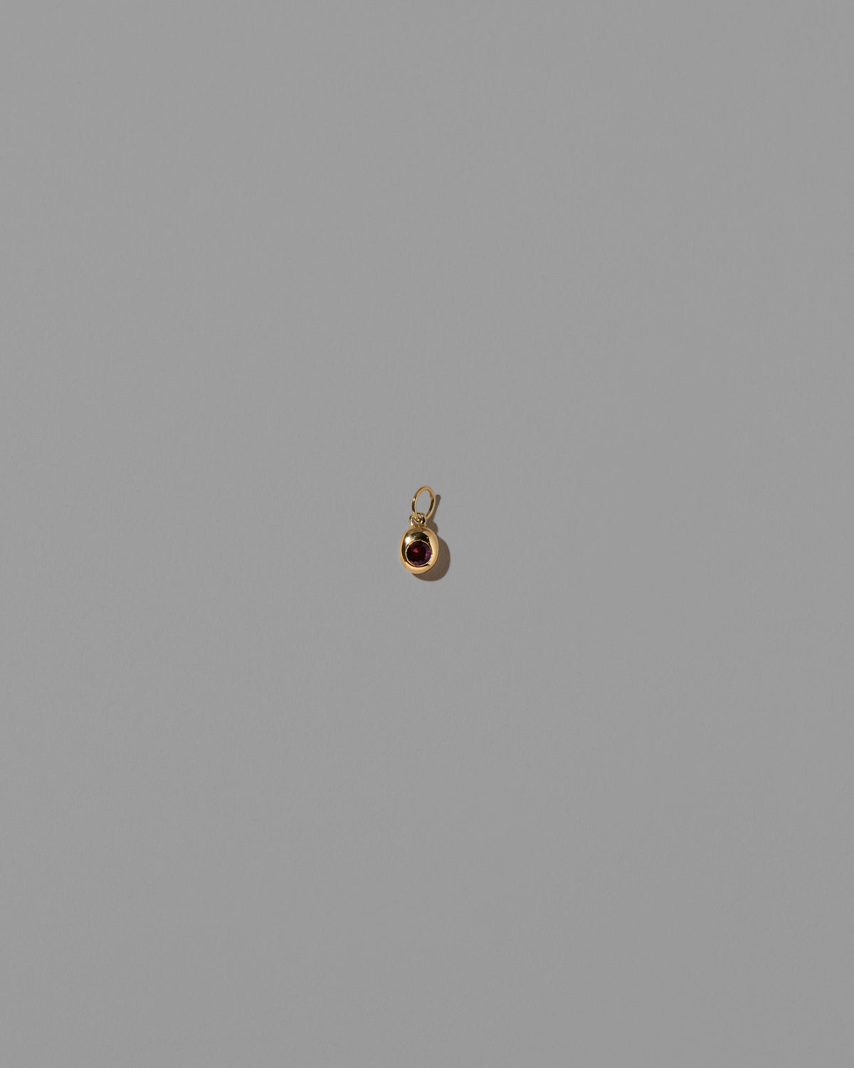Ruby Birthstone Level Charm on light color background.