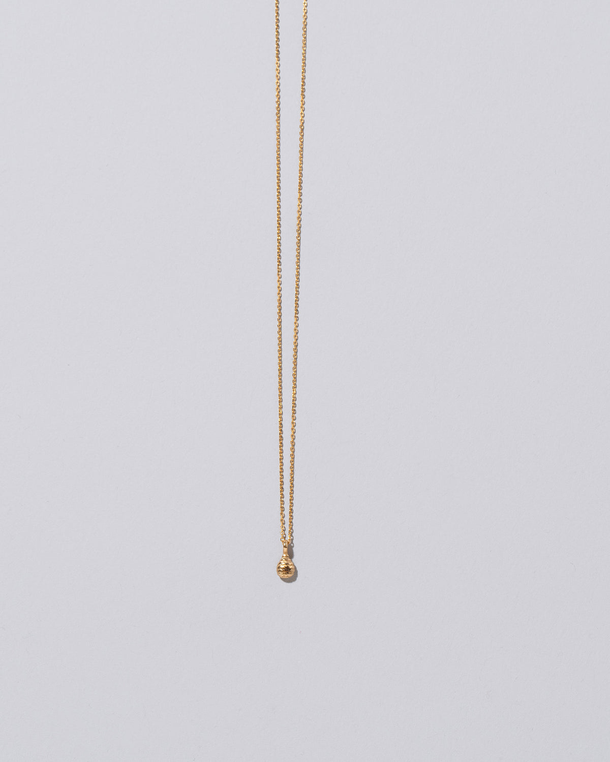 Tear Talisman Pendant Necklace on light color background.