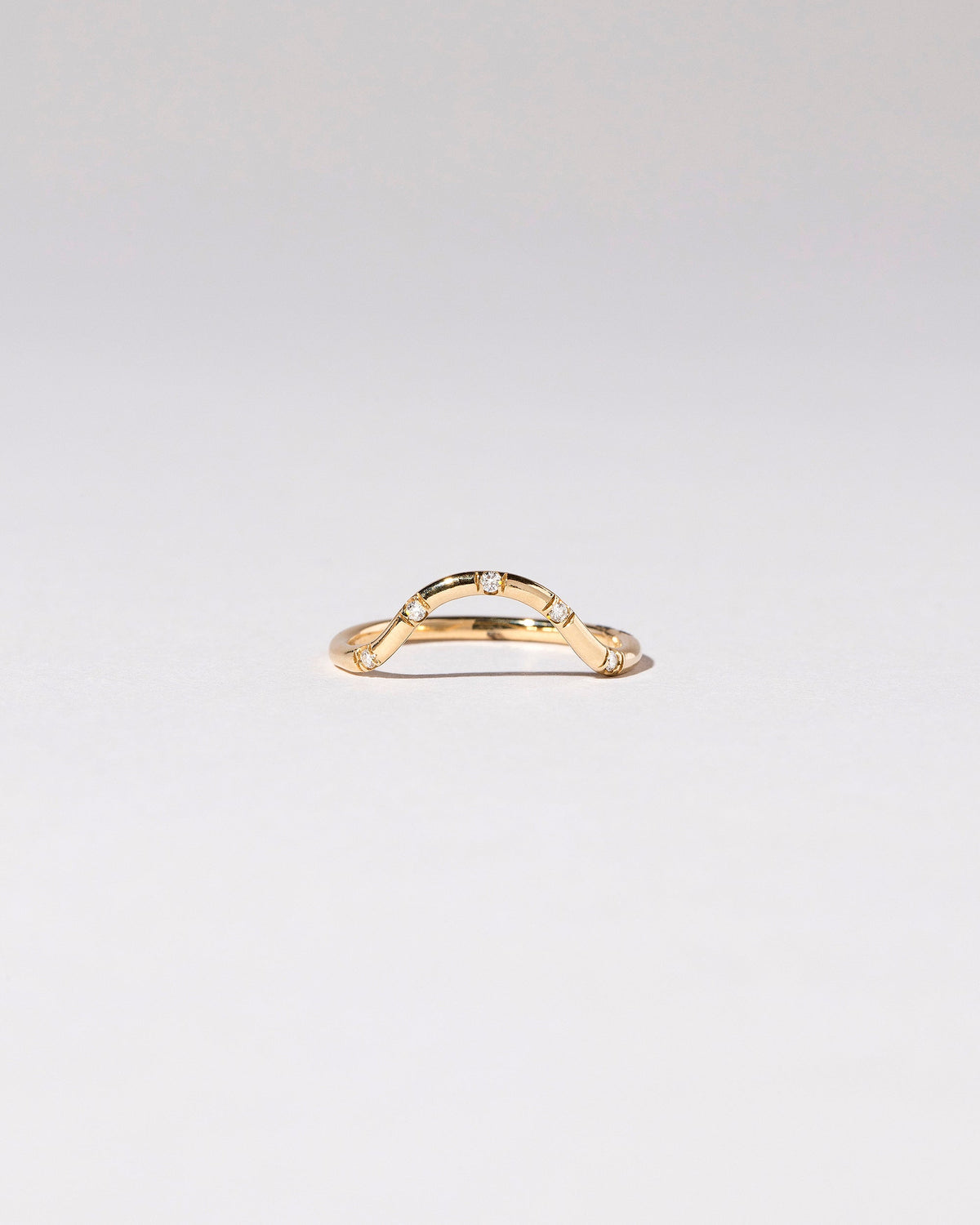 Gold White Diamond Five Stone Curve Band on light color background.