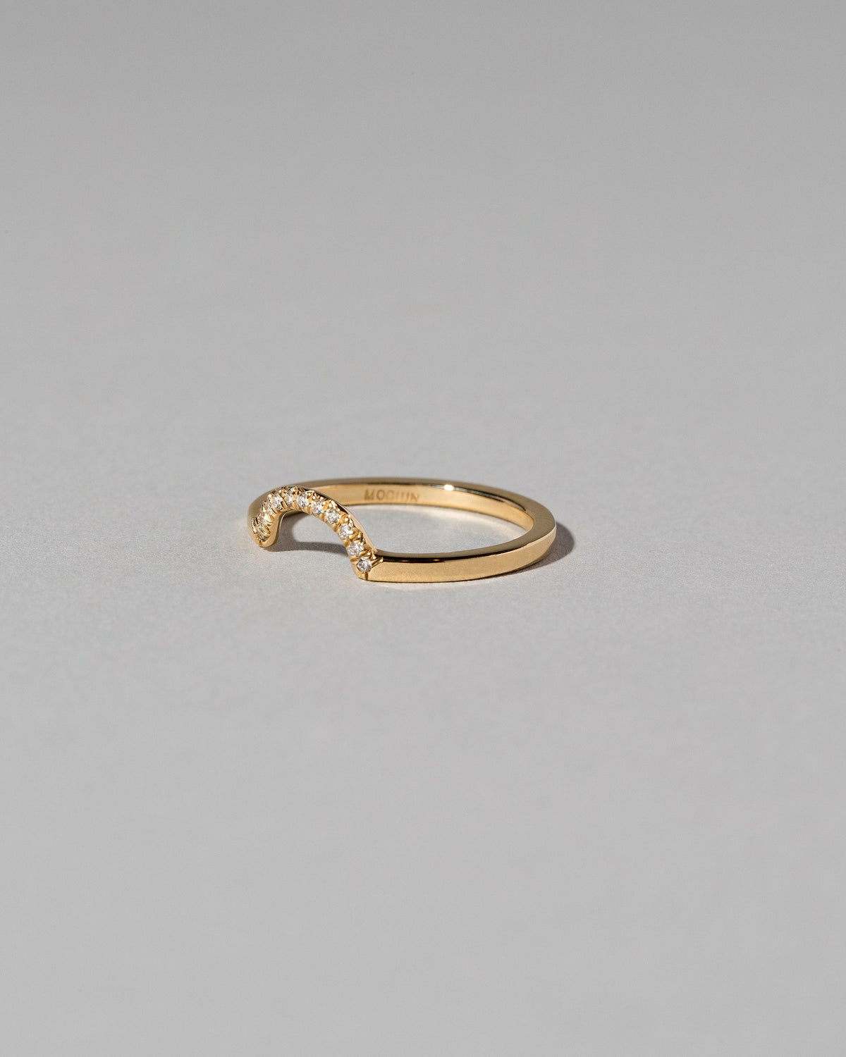 View from the side of the Gold Pavé Mini Half Hoop Band on light color background.