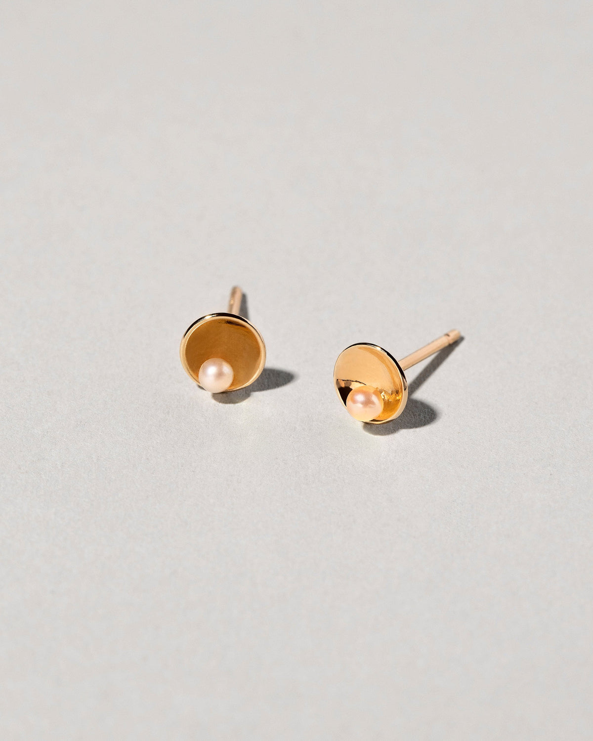  Pearl Cup Earrings on light color background.